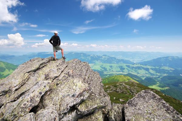 Image: climber on mountain top.