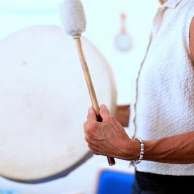Image: woman with drum and mallet.