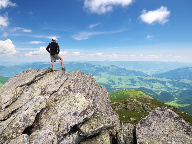 Image: climber on mountain top.